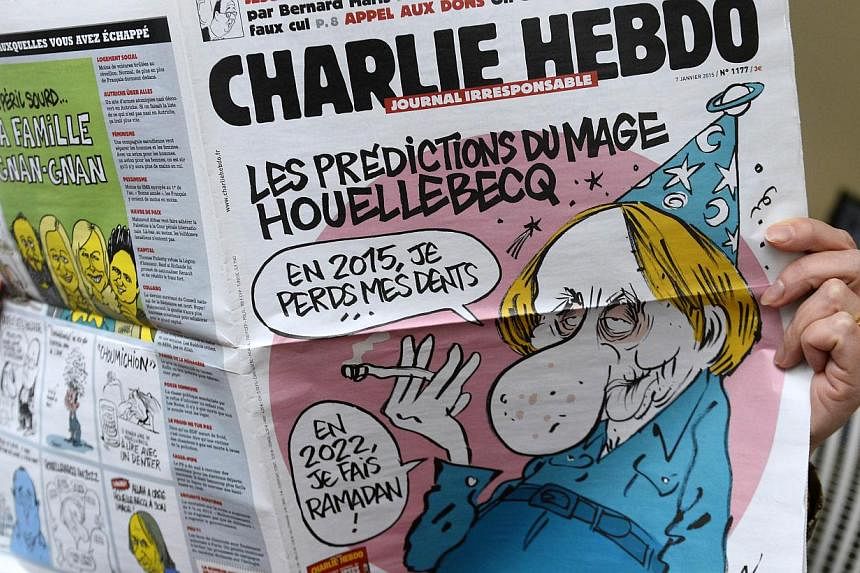 A person reads the latest issue of the French satirical newspaper Charlie Hebdo in Paris on Jan 7, 2015, after gunmen armed with Kalashnikovs and a rocket-launcher opened fire in the offices of the weekly in Paris. -- PHOTO: AFP