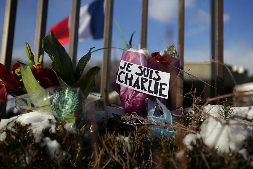 Flowers placed at in the French Embassy in Washington, DC on Jan 7, 2015, in tribute to victims of the attack on satirical magazine Charlie Hebdo in Paris. -- PHOTO: AFP