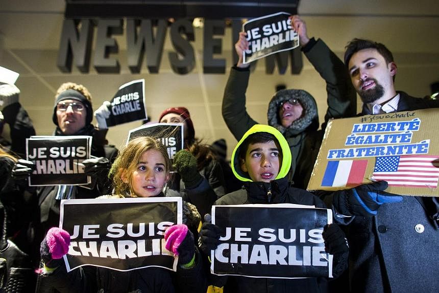Participants holding signs that read "Je Suis Charlie" (I am Charlie) during a vigil for the victims of the attack on the Paris offices of satirical magazine Charlie Hebdo outside the Newseum in Washington, DC, USA, on Jan 7, 2015. -- PHOTO: EPA