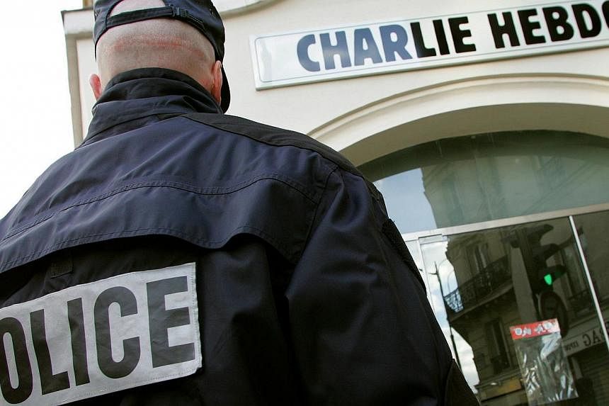 A policeman stands guard outside the French satirical weekly "Charlie Hebdo" in Paris on Feb 9, 2006. -- PHOTO: REUTERS