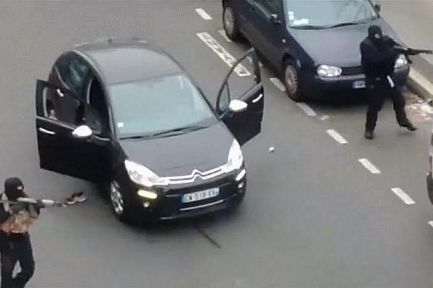 Gunmen fleeing the offices of French satirical newspaper Charlie Hebdo in Paris, in this still image taken from amateur video shot on Jan 7, 2015, and obtained by Reuters. -- PHOTO: REUTERS