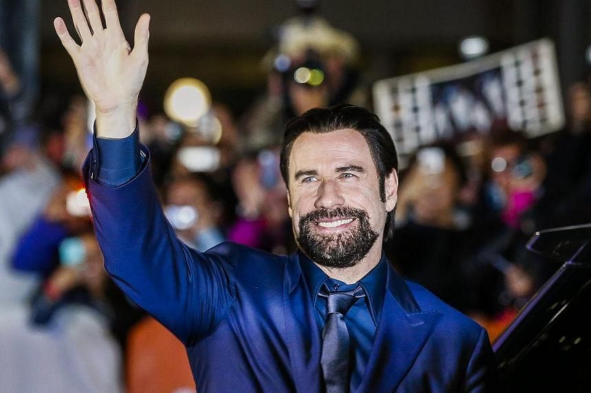 Cast member John Travolta waves upon arrival for the The Forger gala at the Toronto International Film Festival on Sept 12, 2014. He will return to television in a starring role for the first time since 1970s comedy Welcome Back, Kotter. -- PHOTO: RE