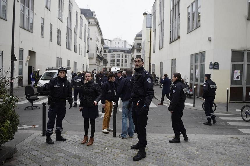 Police forces gather in street outside the offices of the French satirical newspaper Charlie Hebdo in Paris on Jan 7, 2015. The calm, cold determination and deadly efficiency of the gunmen who attacked a French satirical magazine on Wednesday, leavin