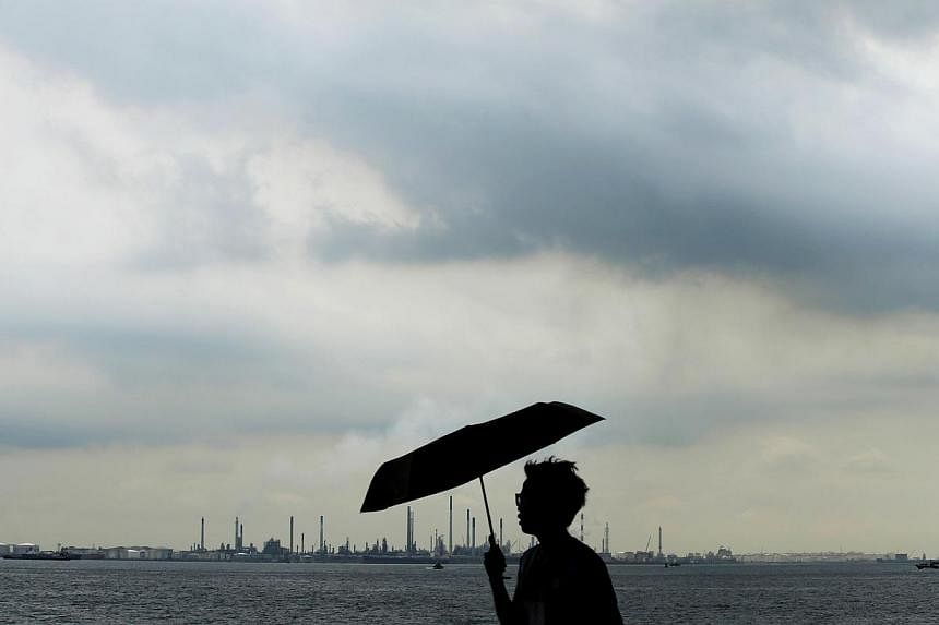 Storm clouds gathering over Shell's Pulau Bukom oil refinery in Singapore on Dec 17, 2014. Oil extended gains in Asia Thursday following a drop in US crude stockpiles. -- PHOTO: REUTERS