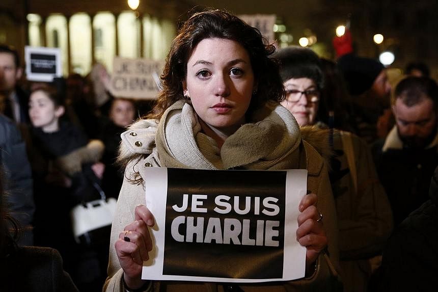 A woman holding a placard that reads, "I am Charlie", during a vigil to pay tribute to the victims of a shooting by gunmen at the offices of weekly satirical magazine Charlie Hebdo in Paris, at Trafalgar Square in London on Jan 7, 2015. -- PHOTO: REU
