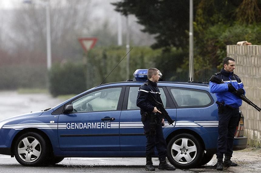 Police officers create a security zone around an industrial area where the suspects in the shooting attack at the satirical French magazine Charlie Hebdo headquarters are reportedly holding a hostage, in Dammartin-en-Goele, some 40 kilometres north-e