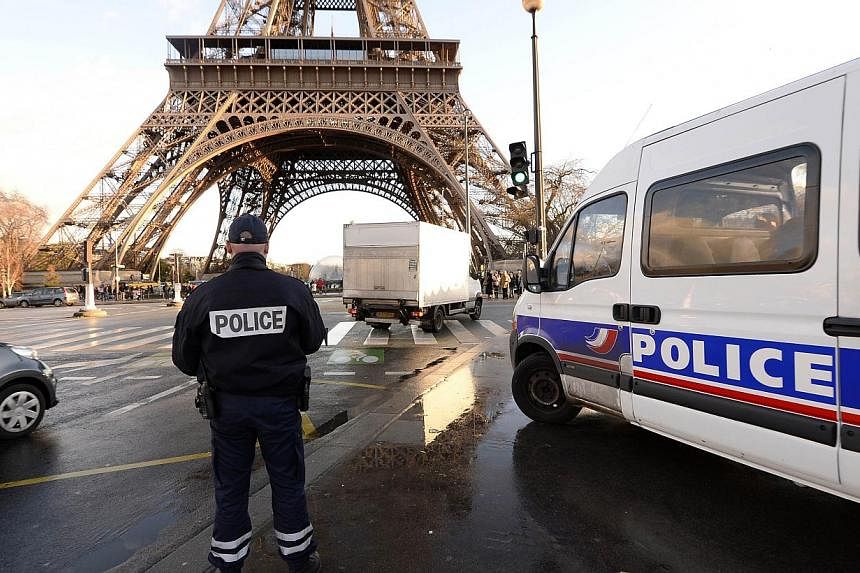 A French police officer stands in front of the Eiffel Tower on Jan 8, 2015 in Paris. Having known ties to jihadist groups is no guarantee a person will be under constant surveillance by the French authorities, experts say. -- PHOTO: AFP&nbsp;
