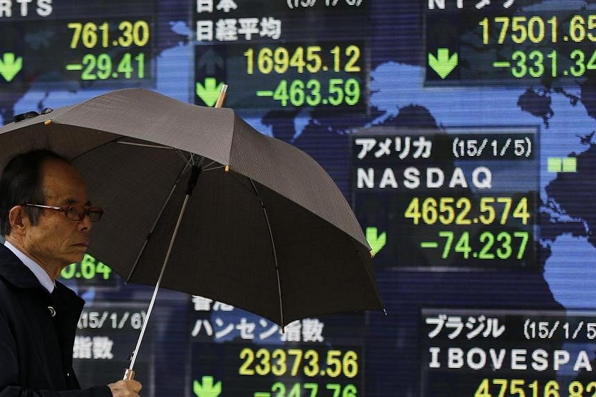 An electronic board displaying Japan's Nikkei average and various countries' stock price index outside a brokerage in Tokyo. Asian stocks gained on Friday on upbeat expectations for the closely-watched US jobs data. -- PHOTO: REUTERS
