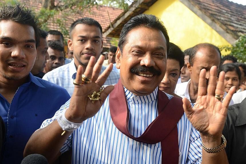 Sri Lankan President Mahinda Rajapakse (centre) waves outside a polling station in his native town of Tangalla on Jan 8, 2015. -- PHOTO: AFP