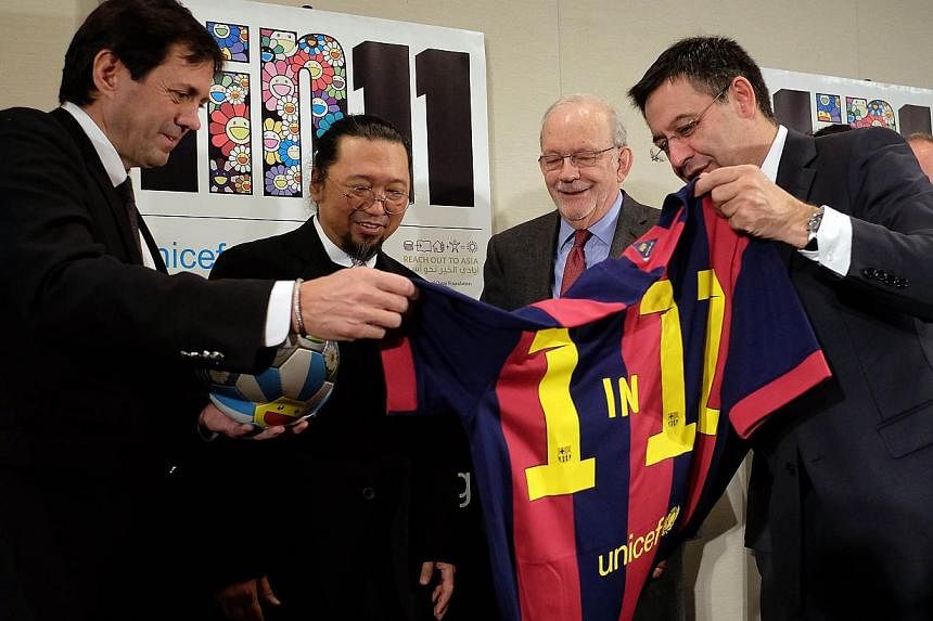 FC Barcelona President Josep Maria Bartomeu (right) shows a jersey reading "1 in 11" to artist Takashi Murak of Japan (second, left) and Unicef Executive Director Anthony Lake (second, right) during the launch the ‘1 in 11’ campaign, in New York 