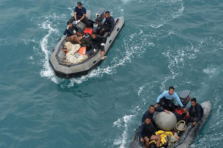Indonesian military divers on Saturday chased faint signals believed to be from the black box data recorders of Indonesia AirAsia flight QZ8501 that crashed in stormy weather, killing all 162 people on board. -- PHOTO: AFP&nbsp;