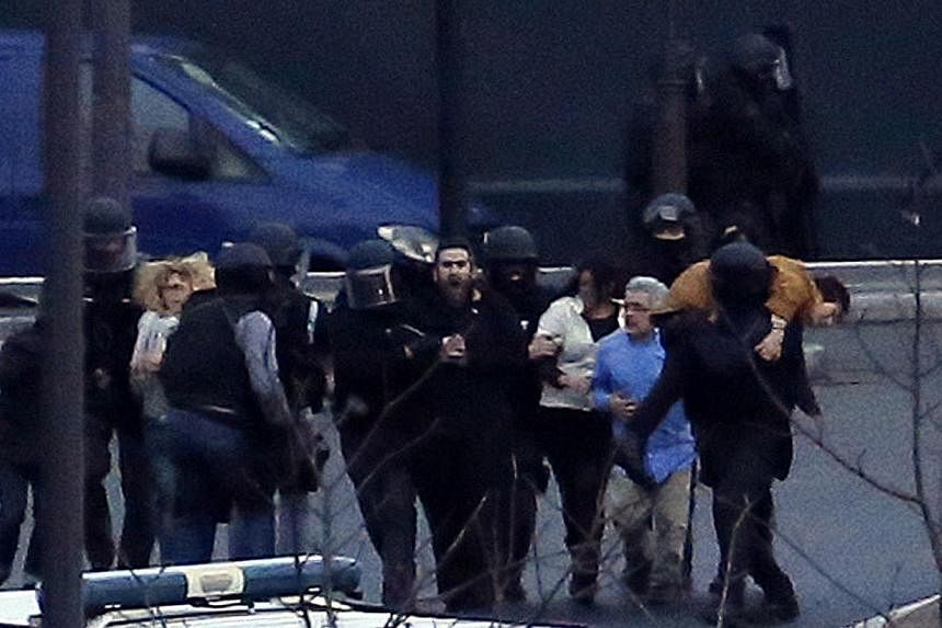Members of the French police special forces evacuate the hostages after launching the assault at a kosher grocery store in Porte de Vincennes, eastern Paris, on Jan 9, 2015. -- PHOTO: AFP&nbsp;