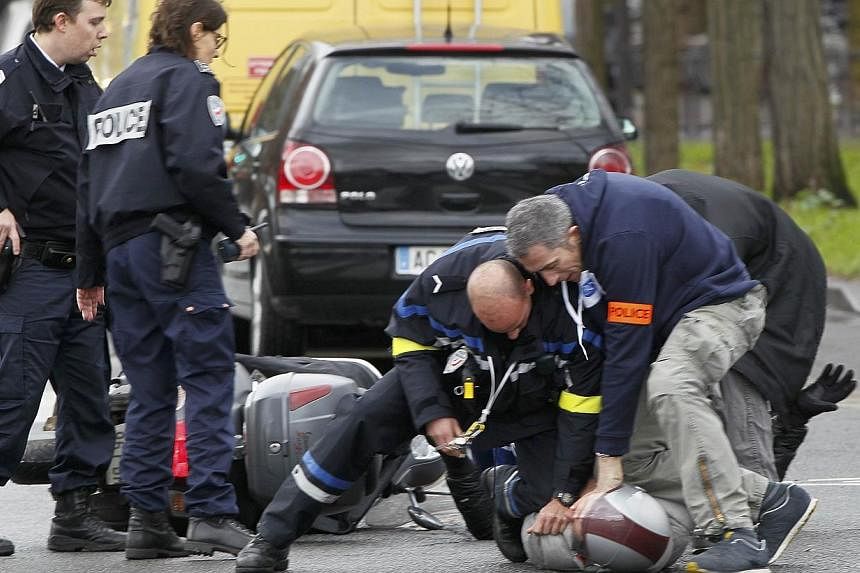 French police forcibly stop at gun point young people on a scooter as they arrive near the scene of a hostage taking at a kosher supermarket in eastern Paris on Jan 9, 2015, following Wednesday's deadly attack at the Paris offices of weekly satirical