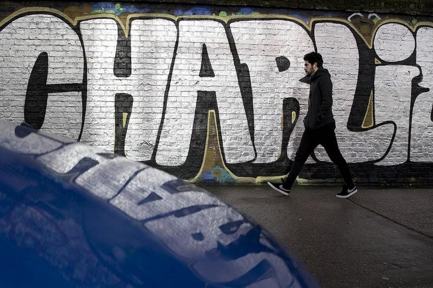 A pedestrian walks past graffiti that reads "[Je suis] Charlie" (I am Charlie), in east London on Jan 10, 2015.&nbsp;Hundreds in southern Afghanistan rallied to praise the killing of 12 people at the French newspaper Charlie Hebdo, calling the two gu