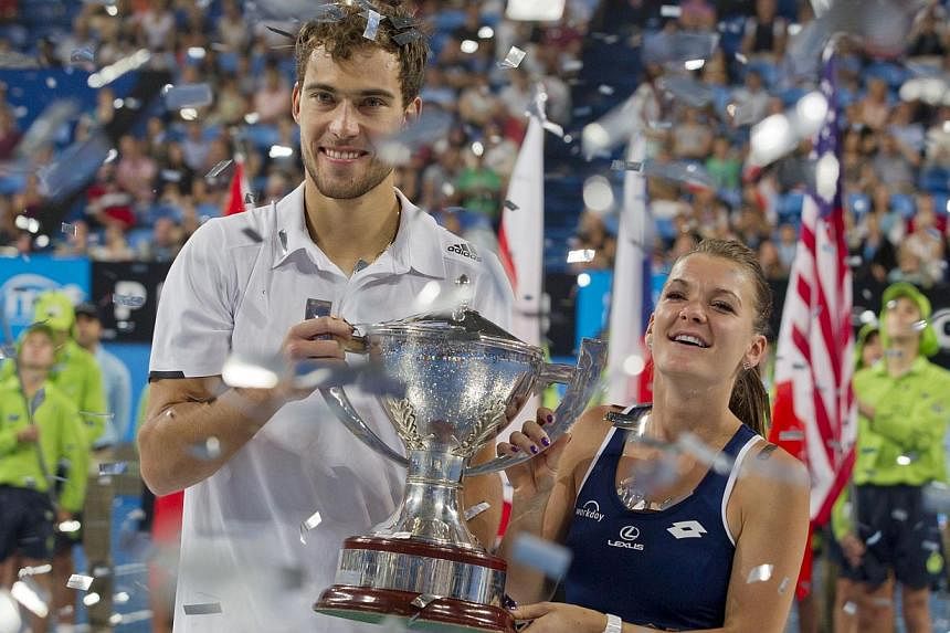 Agnieszka Radwanska (right) and Jerzy Janowicz of Poland pose with the winner's trophy after beating Serena Williams and John Isner of the US in the mixed doubles during the final match on day seven of the Hopman Cup tennis tournament in Perth on Jan