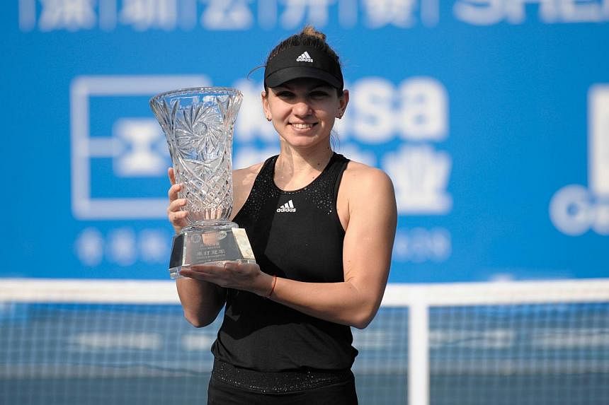 Simona Halep of Romania poses with her winner's trophy after defeating Timea Bacsinszky of Switzerland in their singles final match at the Shenzhen Open WTA Tennis tournament in Shenzhen, south China's Guangdong province on Jan 10, 2015. -- PHOTO: AF