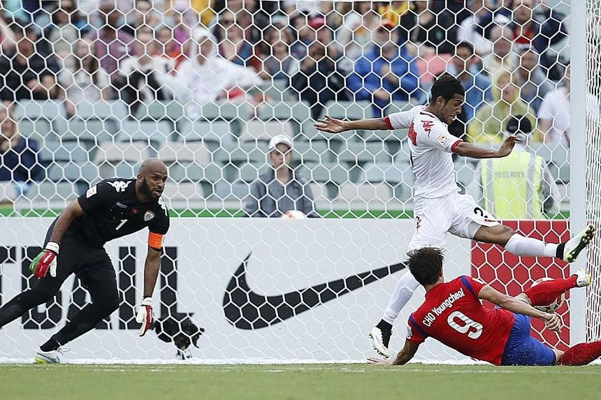 South Korea's Cho Young-cheol (right) scores a goal past Oman's goalkeeper Ali Al-Habsi (left) and Oman's Mohammed Al-Musalami during their Asian Cup Group A soccer match at the Canberra stadium in Canberra Jan 10, 2015. -- REUTERS
