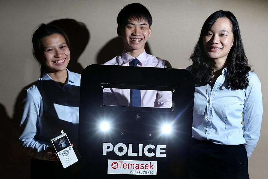 Engineering students (from left) Florence Quek, Ng Jun Hong and Low Siyi with their prototype anti-riot shield. It features strobe lights to blind rioters and a camera that can wirelessly relay footage.