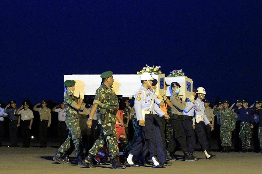 Indonesian officers carry a coffin on its way to Surabaya during a search and rescue operation for a crashed AirAsia plane, at Iskandar Military Airport in Pangkalan Bunn, Central Borneo, Indonesia, on Jan 9, 2015. -- PHOTO: EPA