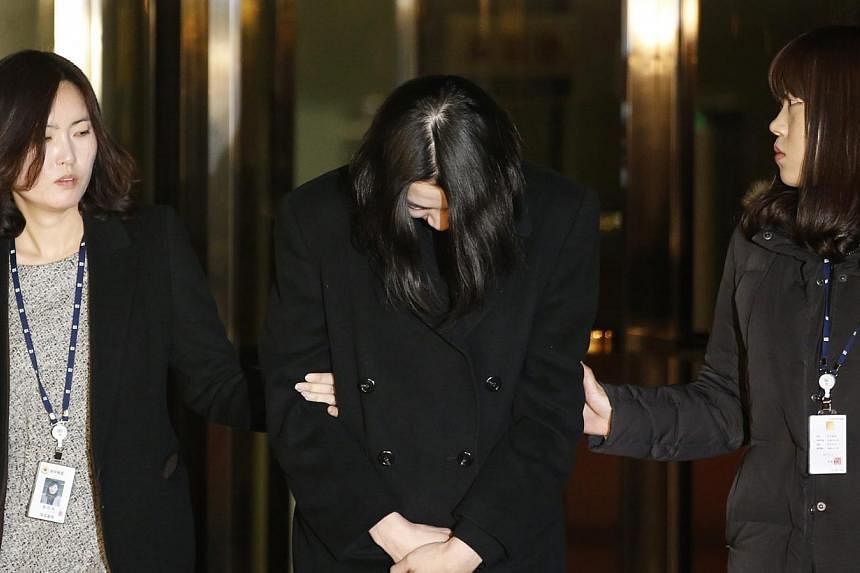 Heather Cho (centre), daughter of chairman of Korean Air Lines, Cho Yang Ho, leaves the Seoul Western District Prosecutor’s office for a detention facility after a Korean court ordered her to be detained on Dec 30, 2014. -- PHOTO: REUTERS