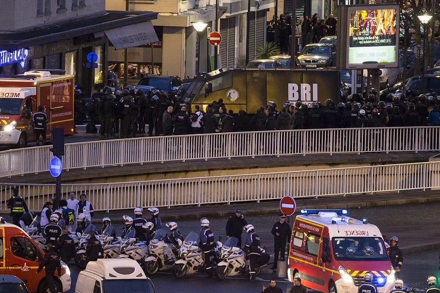 Members of the BRI police elite unit gather during an assault on the HyperCasher supermarket at Porte de Vincennes in Eastern Paris after a gunman opened fire and took hostages, on the border of Paris and its suburb Sain-Mande, on Jan 9, 2015. -- PHO