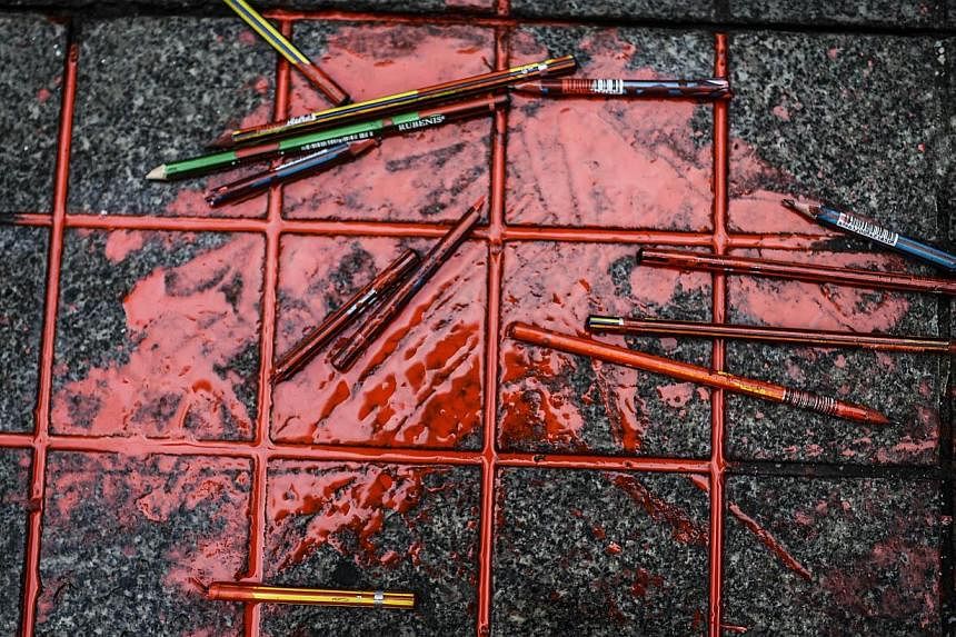 Pencils with red ink are placed in front of the French Consulate in Istanbul after a demonstration for the victims of the January 7 massacre at the Charlie Hebdo magazine offices in Paris on Jan 9, 2015. -- PHOTO: AFP