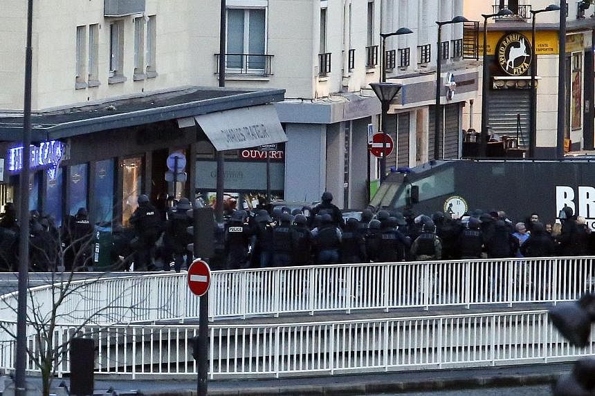 Members of the French special police forces launch the assault at a kosher grocery store in Porte de Vincennes, eastern Paris, on Jan 9, 2015. -- PHOTO: AFP