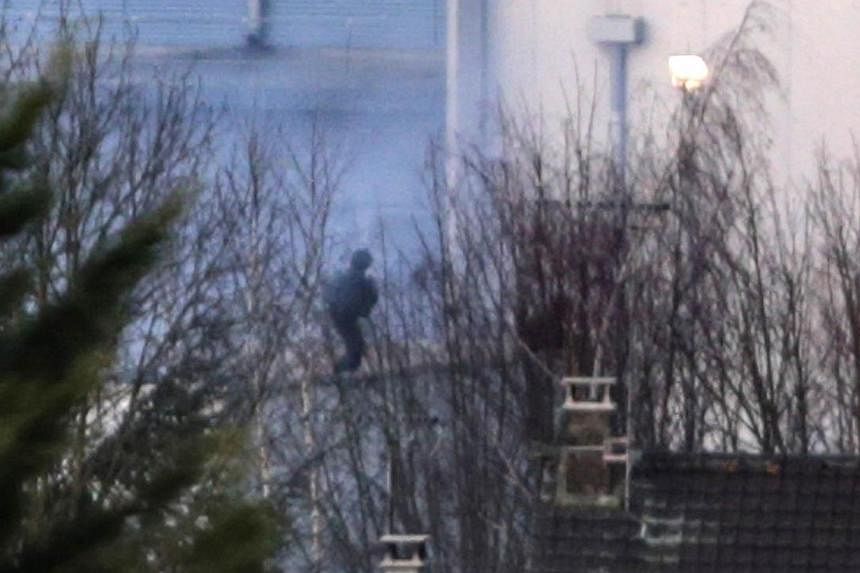 French commandos (centre) launch an assault as smoke rises from a building in Dammartin-en-Goele, north-east of Paris, where two brothers suspected of killing 12 people in an Islamist attack on French satirical newspaper Charlie Hebdo held one person