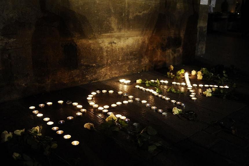 Lit candles forming the word "peace" in French outside the Capitole building in Toulouse, southern France, &nbsp;during a gathering to pay tribute to the victims of a deadly attack on the Paris headquarters of French satirical weekly Charlie Hebdo. A