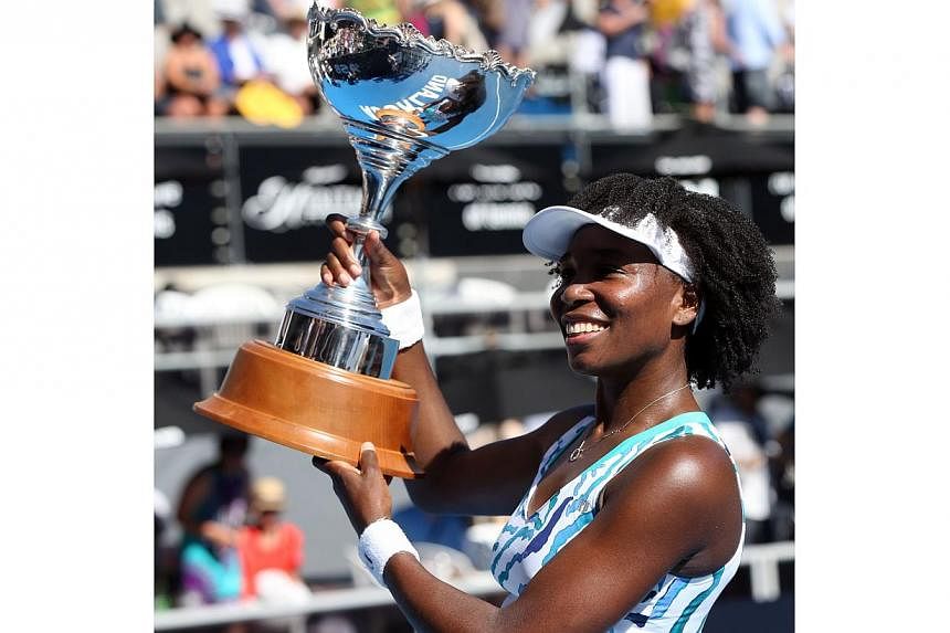 Venus Williams of the US celebrates with the trophy after beating Caroline Wozniacki of Denmark during their women's singles final at the ASB Classic tennis tournament in Auckland on Jan 10, 2015. -- PHOTO: AFP
