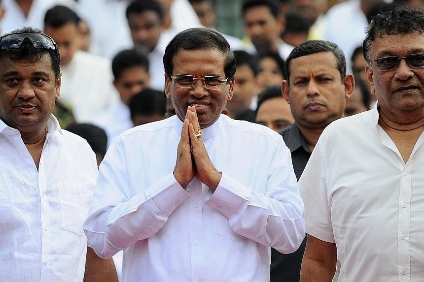 Sri Lankan President Maithripala Sirisena gestures as he arrives to address the nation from outside the Buddhist Temple of Tooth in the central town of Kandy on Jan 11, 2015. -- PHOTO: AFP