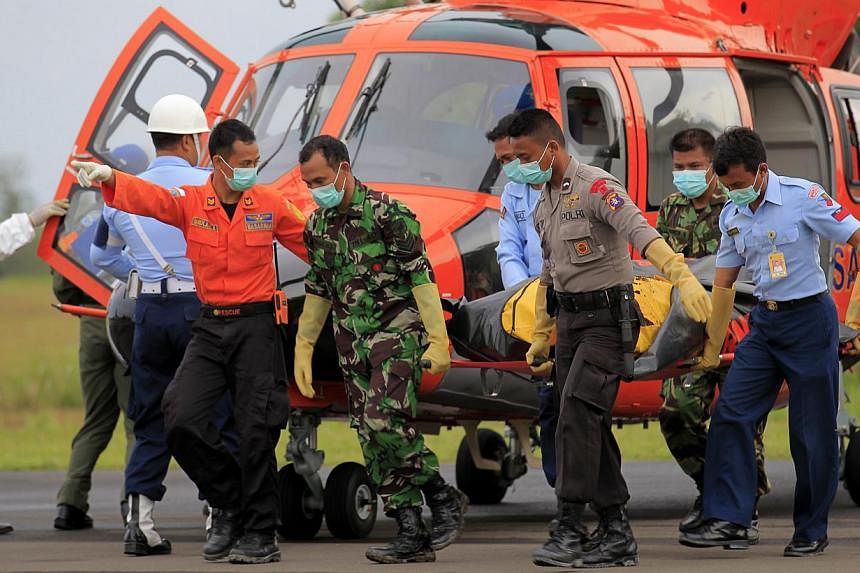 Members of the Indonesian national search and rescue agency (BASARNAS) carry the body of a victim of a crashed AirAsia plane at Iskandar Military Airport in Pangkalan Bun, Central Borneo, Indonesia on Jan 9, 2015.&nbsp;-- PHOTO: EPA