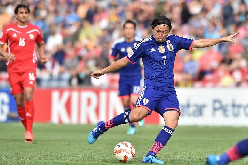 Yasuhito Endo of Japan (centre) shoots to score a goal against Palestine during their Group D football match of the AFC Asian Cup in Newcastle on Jany 12, 2015.&nbsp;An early 30-metre strike by Endo set Japan's Asian Cup title defence off to the perf