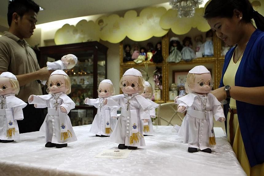Shop workers arrange miniature Pope Francis dolls, which measure 12-inches (30cm) in height, at a gift shop in Makati, Metro Manila on Jan 12, 2015. -- PHOTO: REUTERS