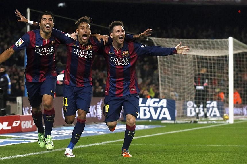 (From left) Barcelona's Luis Suarez, Neymar and Lionel Messi celebrate a goal against Atletico Madrid during their Spanish First Division football match at Camp Nou stadium in Barcelona on Jan 11, 2015.&nbsp;-- PHOTO: REUTERS