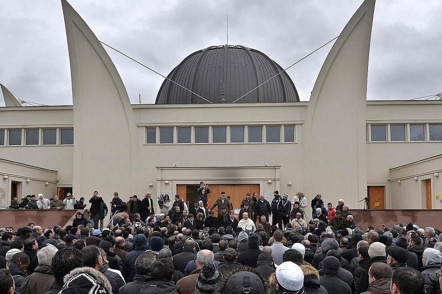Hundreds of Muslims gathering outside the Grande Mosquee in Strasbourg, eastern France, to observe a minute of silence last Friday following the Charlie Hebdo attack which left 12 people dead. People holding up pens during a vigil in Lyon last Wednes