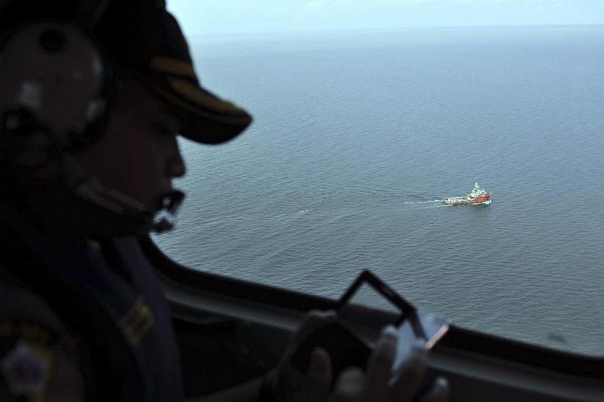 An Indonesian policeman watches from the air as the search operation in the Java sea goes underway. Indonesia's search and rescue agency said on Monday morning that search teams had managed to get part of the flight data recorder of the Indonesia Air