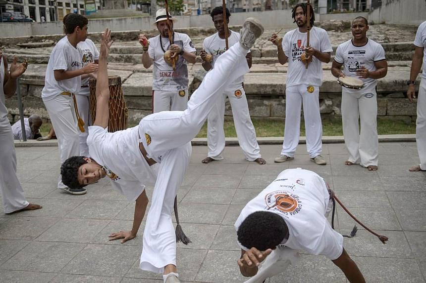 Players of Brazilian Capoeira, a mixture of dance and martial art inherited from the times of slavery, perform to celebrate the nomination of Capoeira to the list of UNESCO's Intangible Cultural Heritage in Rio de Janeiro, Brazil. --PHOTO: AFP