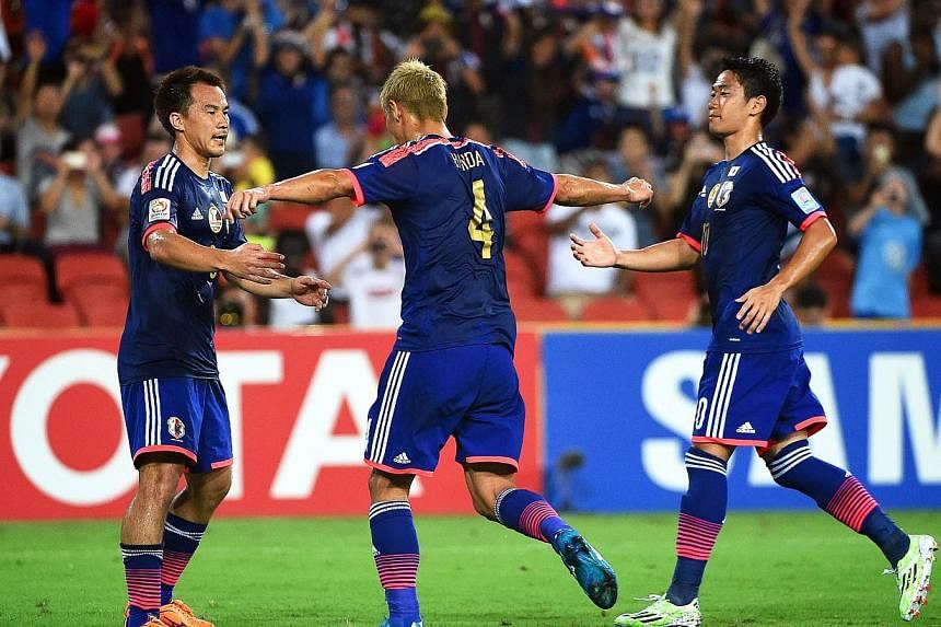 Keisuke Honda (centre) of Japan celebrates with his teammates after scoring the 1-0 lead from the penalty spot during the AFC Asian Cup Group D soccer match between Iraq and Japan in Brisbane, Australia, Jan 16, 2015. -- PHOTO: EPA