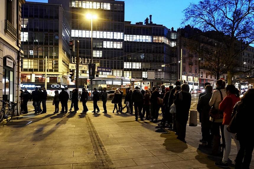 People queue at a currency exchange office in Geneva on Jan 15, 2015. -- PHOTO: AFP