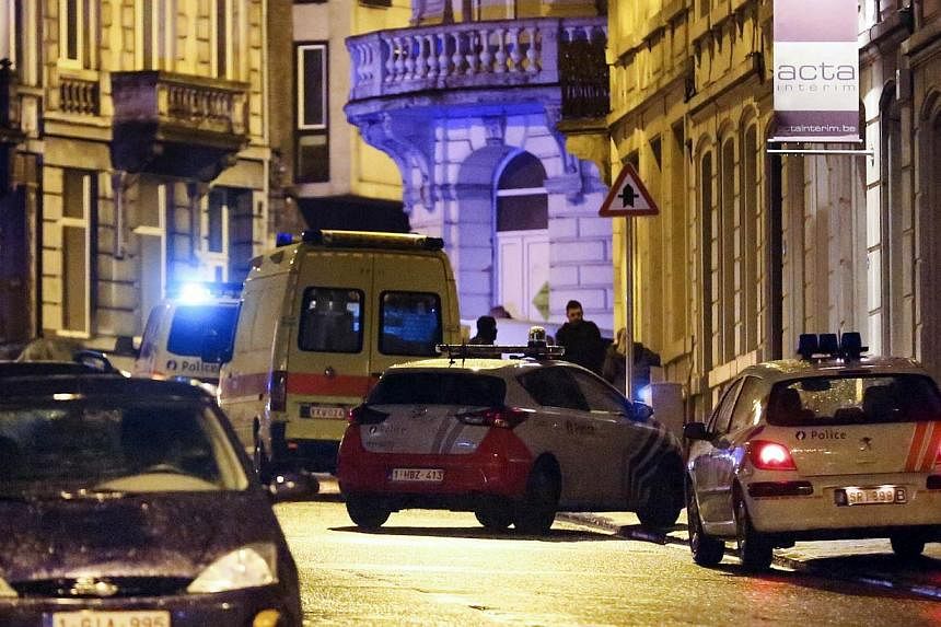 Police cars and vans are parked in a street as police set up a large security perimeter in the city center of Verviers, eastern Belgium, where two people were killed in an anti-terrorism operation on Jan 15, 2015. -- PHOTO: AFP