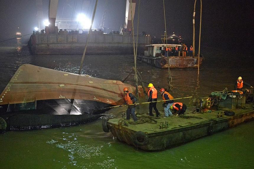 Salvage workers raising the tugboat on in the early hours of Jan 16, 2015. Twenty people, including Singaporeans and Japanese, are reported missing. -- PHOTO: XINHUA