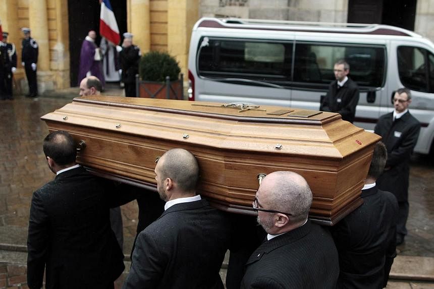Relatives of Franck Brinsolaro, the police officer charged with protecting late Charlie Hebdo editor Stephane Charbonnier, or "Charb", carry his coffin into the Sainte-Croix Church for his funeral on Jan 15, 2015 in the northwestern French town of Be