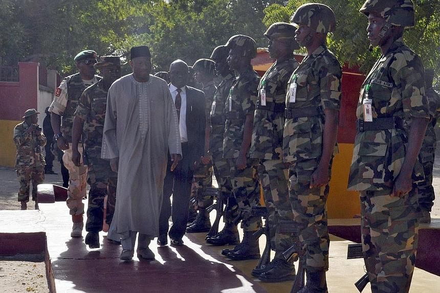 President Goodluck Jonathan (centre left) inspects a guard of honour by soldiers of the 7 Division of the Nigerian Army fighting Boko Haram terrorists during a surprise visit in Maiduguri on Jan 15, 2015. Nigeria's Mr Jonathan met survivors from what