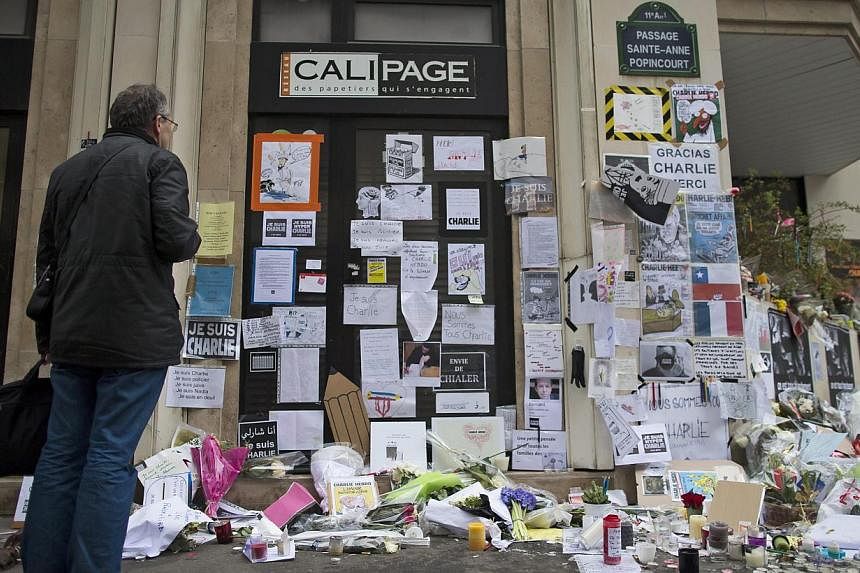 A man pays his respects next to the 'Charlie Hebdo' offices in Paris, France, on Jan 13, 2015. -- PHOTO: EPA