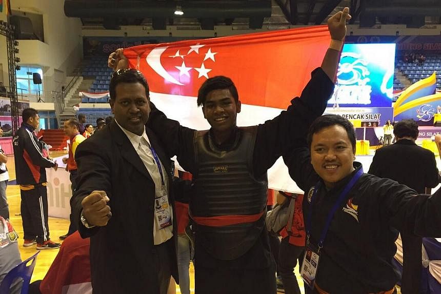 A victorious Sheik Alau'ddin being flanked by his father (left) and national match coach Muhammad Fiqri. -- ST PHOTO: CHUA SIANG YEE