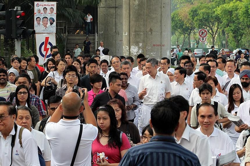 Prime Minister Lee Hsien Loong talking to commuters on his way to Ang Mo Kio MRT station on May 4, 2011. -- PHOTO: ST FILE