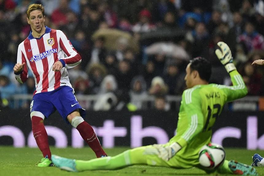 Atletico Madrid's forward Fernando Torres (left) scores during the Spanish Copa del Rey (King's Cup) round of 16 second leg football match Real Madrid CF vs Club Atletico de Madrid at the Santiago Bernabeu stadium in Madrid on Jan 15, 2015. -- PHOTO: