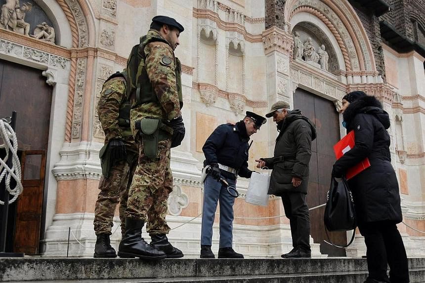 Security personnel check people with metal detectors at the entrance of San Petronio Basilica in Bologna, northern Italy, on Jan 16 2015.&nbsp;Italy has expelled nine suspected Islamist militants so far this year as part of a heightened security aler