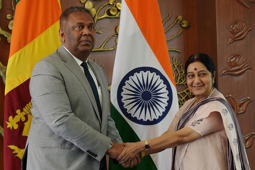 Sri Lankan Foreign Minister Mangala Samaraweera (left) and Indian Foreign Minister Sushma Swaraj shake hands before a meeting in New Delhi on Jan 18, 2015.&nbsp;Sri Lanka's new foreign ministermet his Indian counterpart in New Delhi on Sunday during 